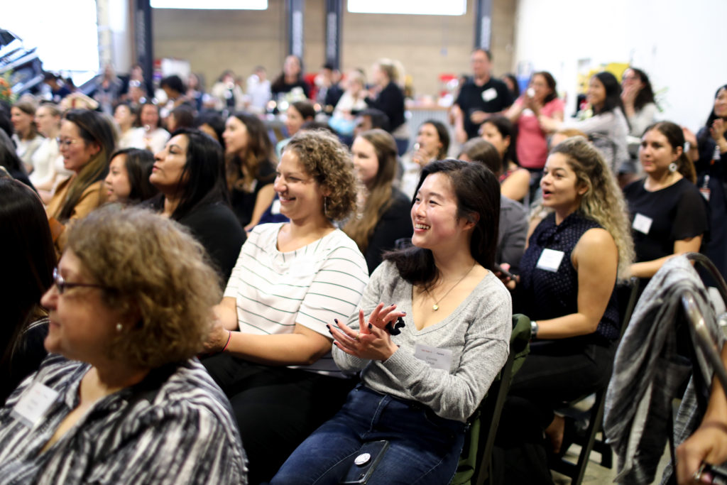 women in tech - diverse group of women sitting in the audience, clapping and laughing during a tech talk at the Aurora Girl Geek Dinner in the San Francisco Bay Area, July 2019. 